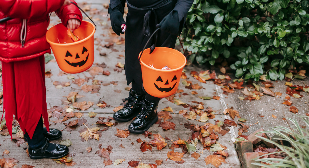 kids trick or treating carrying pumpkin buckets