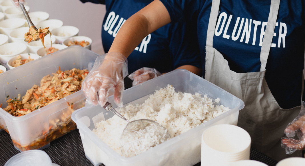kids with shirts that says volunteer, sorting food