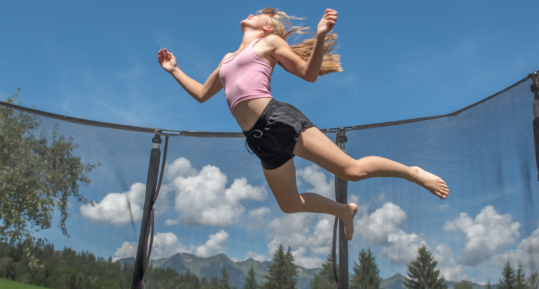 tween girl jumping on trampoline
