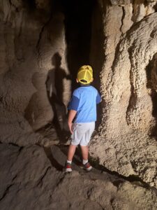 A young boy explores one of the caves behind the waterfalls at Rifle Falls State Park in Colorado.