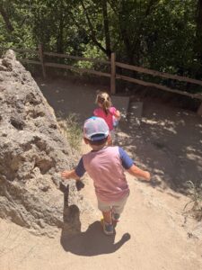 Two young children walk along the trail at Rifle Falls State Park toward the caves behind the waterfalls.